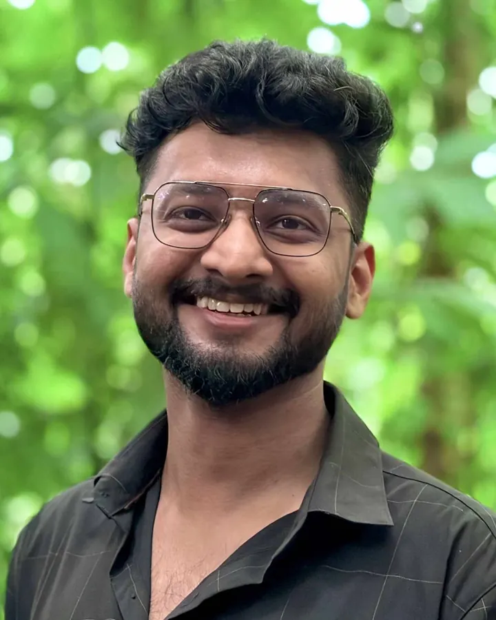 Arun Prakash, smiling, in glasses and a dark shirt